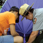 A Ranger shows a young man how to properly set up a tent during a Family Camping Resource Seminar.