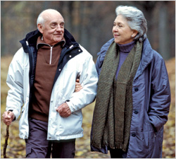 Older man and woman walking outdoors in cool weather