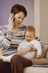 una mujer hablando por teléfono con un bebé en su regazo