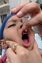 An Indian health worker gives oral polio vaccine to a child in India