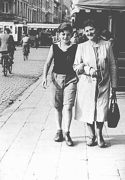 Shoshane Varmel Levy and her son, Jules, wearing the compulsory yellow badge, on a street in Antwerp. Belgium, June 1942.