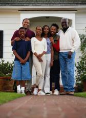 Fotografía de una familia en frente de su casa