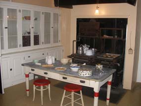 Kitchen showing the cabinets, work table and stove.  Reproduction flooring will be installed within the next two months.