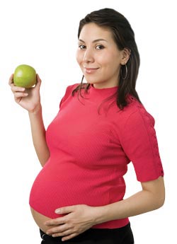 A Pregnant woman holding an apple.