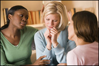 Photo: A woman being comforted by her friends