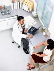 Photograph of a male doctor talking to a female patient