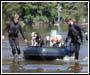 Photo of two rescuers pulling a rubber boat full of dogs