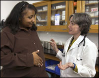 Portada: una madre embarazada en una consulta con su proveedor de atención médica.