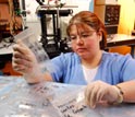 Photo of graduate student Christina Hampton showing samples of drugs.
