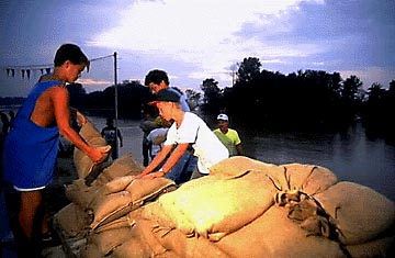 Photo of boys stacking sand bags.