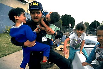 Photo of children playing with a FEMA employee.