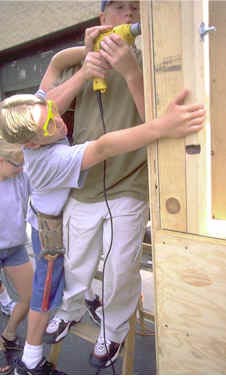 Photo of two students drilling into wood.