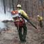 firefighter with leaf blower on trail