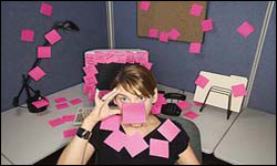Photo: A woman covered in notes sitting in an office cubicle