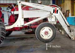 Photo 3 – Right side view of tractor with front bucket powered down to raise the front wheels off the floor.