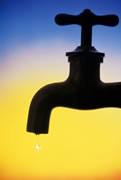 Photo of a water faucet, silhouetted against the horizon