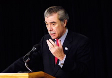 Gutierrez gesturing in front of microphone.