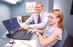 Psychologist and principal investigator teaches student how to perform a computerized test: Click here for full photo caption.