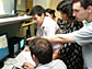 Photo shows Exotic Beam Summer School students viewing progress of their experiments.