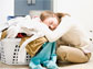 Photo of woman resting her head on basket of laundry.