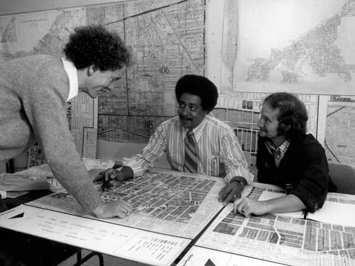 In October 1973, VISTA volunteers Steve Roberts (left) and Thomas J. Van Dalen (right) review a map of the Hough area of Cleveland, which they prepared to indicate the condition of every building in the area. 