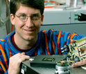 Photo of Steve Potter holding a device that creates a neural network - computer interface.