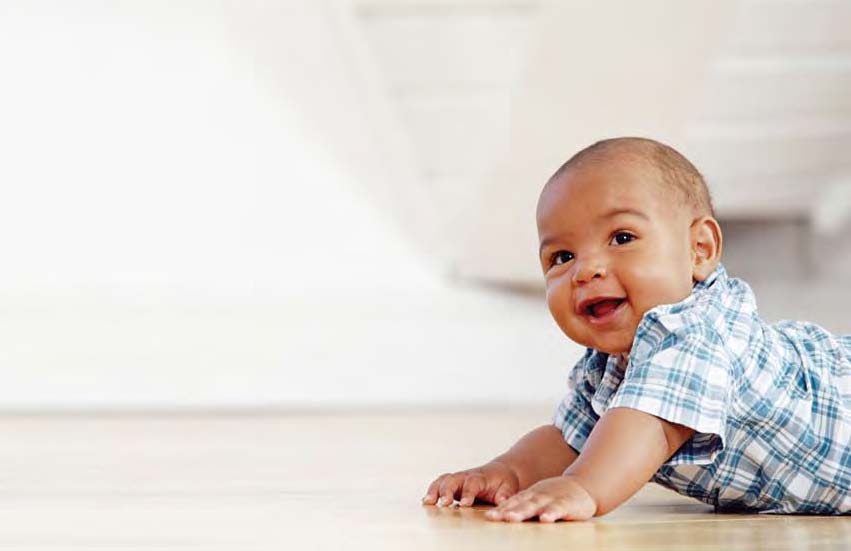 Photo of baby boy crawling on the floor.