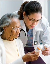 Older woman and health care professional looking at medicine bottles