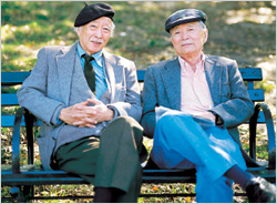 Two older men sitting on a park bench