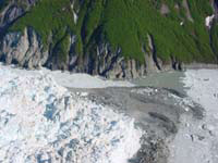 June 13, 2002, south-close-up-view from above the advancing terminus of Hubbard Glacier of the channel cut into the top of the push moraine that blocked the mouth of Russell Fiord. A push moraine is sediment bulldozed from the floor of Russell Fiord by the advancing ice. Some of this sediment can be seen in contact with the bedrock on the south wall of the fiord. This photograph was made at high tide. USGS Photograph by Bruce F. Molnia (6/13/02-51).