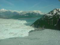 June 13, 2002, northeast-up-view from south of the advancing terminus of Hubbard Glacier, of the push moraine that blocked the mouth of Russell Fiord. A push moraine is sediment bulldozed from the floor of Russell Fiord by the advancing ice. Part of the glacier that is advancing into Russell Fiord can be seen in the center of the photograph. USGS Photograph by Bruce F. Molnia (6/13/02-60).