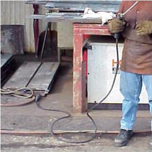 Photo: Welder holding equipement and trailing insulated wire