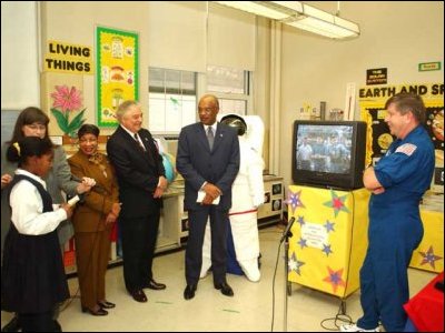 A student at Washington, D.C.'s John Quincy Adams Elementary School has a question for astronauts aboard the International Space Station, with Secretary Paige (center), D.C. schools superintendent Paul Vance (left) and NASA astronaut Roger Crouch (right).