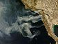 Satellite image of smoke from Southern California wildfires billowing over the Pacific Ocean.