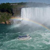 photograph of Niagra Falls with a rainbow over a tour boat