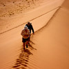 photo of two people walking along the top of a sand ridge