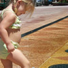 photo of a small girl with her toes in a street level fountain