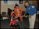 Mission Specialist Alvin Drew and experts from the Challenger Learning Center teach students about spatial disorientation using the Bárány Chair.