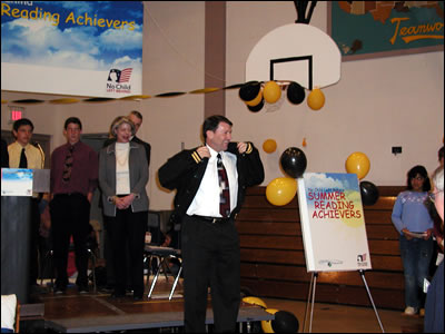 SD Governor Mike Rounds accepts a North Middle School jacket at the Summer Reading Achievers kickoff held in Rapid City, SD, while Assistant Secretary Laurie Rich looks on.