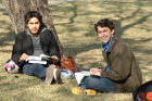 Two males studying outside sitting on the lawn.