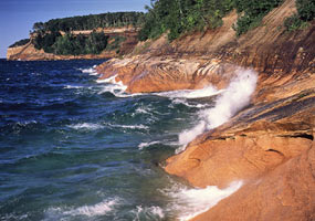 Lake Superior waves splash onto the Pictured Rocks cliffs.