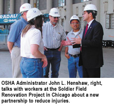 OSHA Administrator John L. Henshaw, right, talks with workers at the Soldier Field Renovation Project in Chicago about a new partnership to reduce injuries.