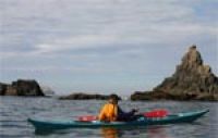 Kayaker exploring California's offshore rocks