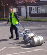 Fig. 1b: Employee using clamping device to transport the keg.