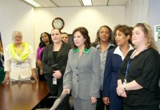 Secretary Solis views a display containing photographs of past Women's Bureau Directors during her recent visit to the agency's National Office.