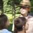 A park ranger leading a guided tour for elementary school children.
