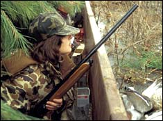 Female hunter with rifle in the brush