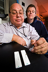 Biologist (foreground) and biochemist evaluate the results of an assay, developed with a corporate partner, designed to detect botulism toxin in as little as 15 minutes from a single drop of sample: Click here for full photo caption.