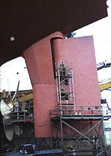 Worker on independent metal pole scaffold protected with guardrails