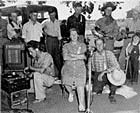 Mr. and Mrs. Frank Pipkin being recorded by C. Todd with 7 men and a little boy in the background